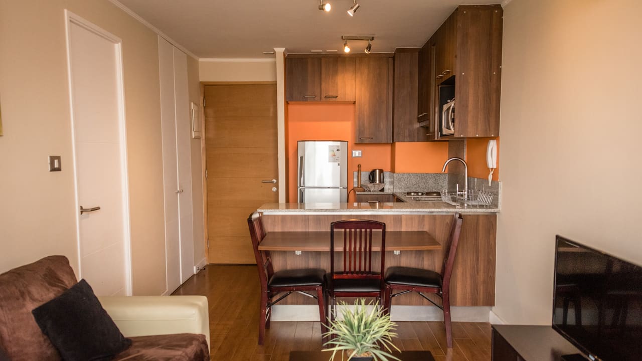 Living comedor con cocina americana de un departamento Torre del Sol